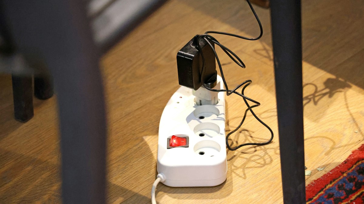 木の床に置かれたコンセント付きの電源タップ